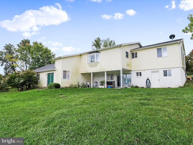 back of property featuring a patio area and a lawn