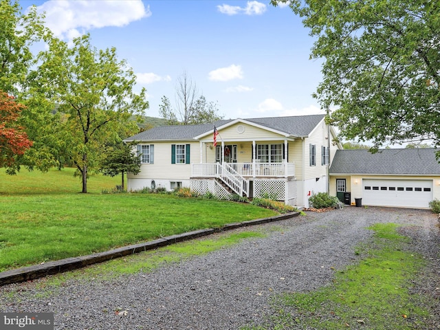 view of front facade with a garage, a porch, and a front lawn