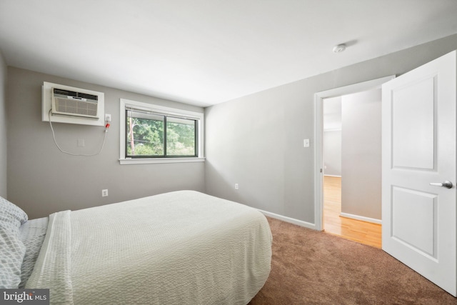 carpeted bedroom featuring a wall mounted air conditioner and baseboards