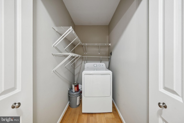 laundry room featuring wood finished floors, washer / clothes dryer, baseboards, and laundry area