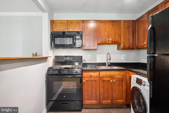 kitchen featuring washer / dryer, brown cabinetry, tile patterned floors, black appliances, and a sink