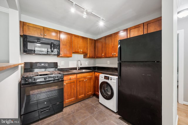 kitchen with black appliances, brown cabinetry, a sink, and washer / dryer