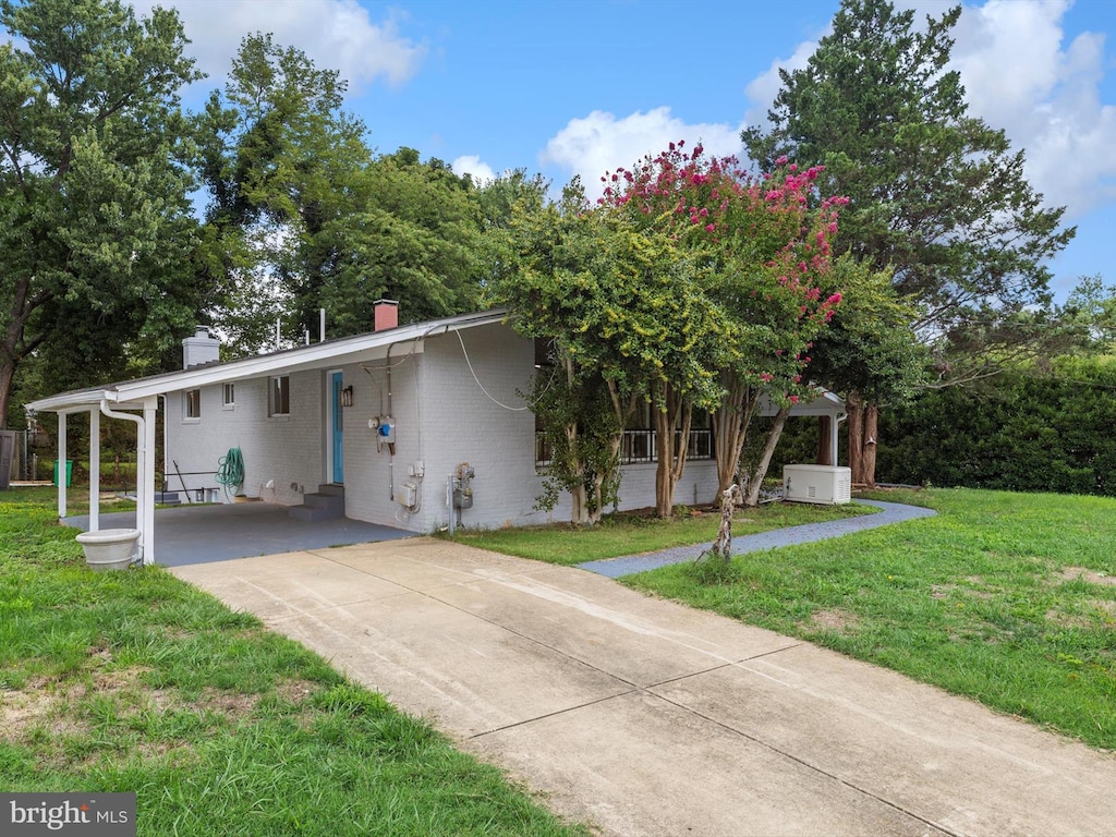 view of front of property with a front lawn and a carport