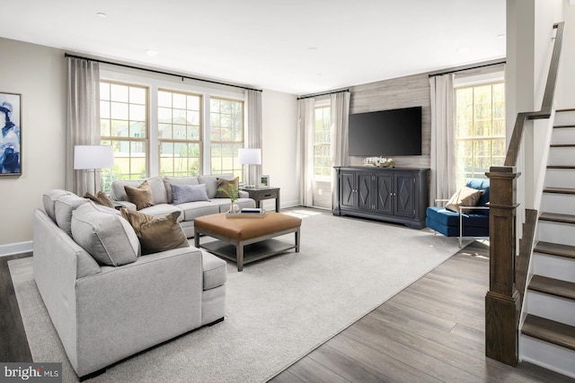 living room with stairway, baseboards, and wood finished floors