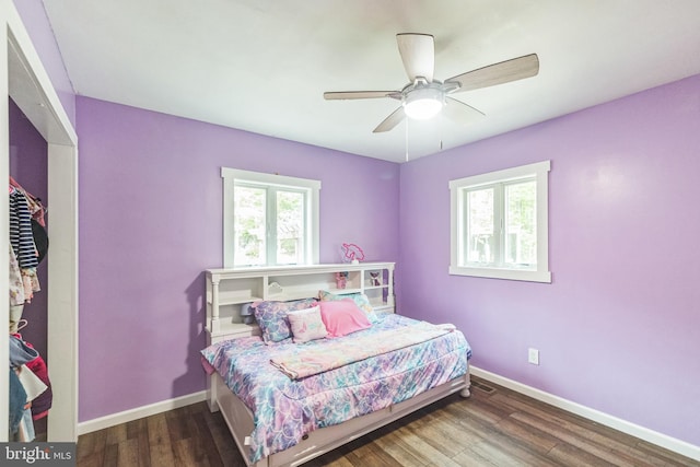 bedroom featuring wood finished floors, a ceiling fan, and baseboards