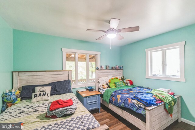 bedroom featuring a ceiling fan, baseboards, and wood finished floors