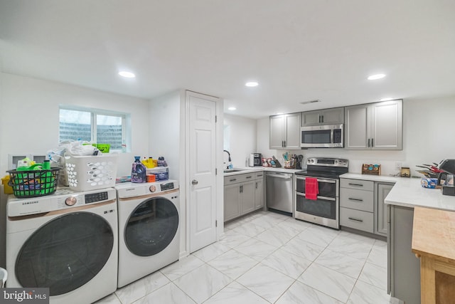 laundry room with laundry area, independent washer and dryer, marble finish floor, a sink, and recessed lighting