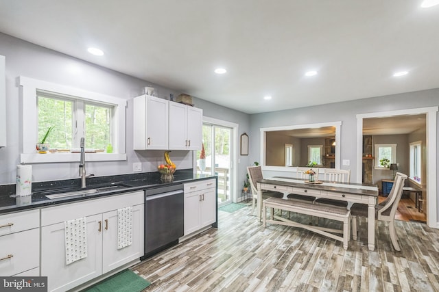 kitchen with light wood finished floors, dishwasher, white cabinetry, a sink, and recessed lighting