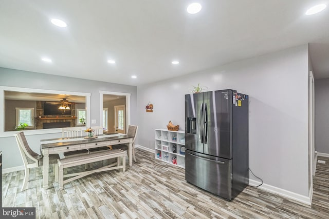 kitchen featuring ceiling fan, recessed lighting, wood finished floors, baseboards, and stainless steel fridge with ice dispenser