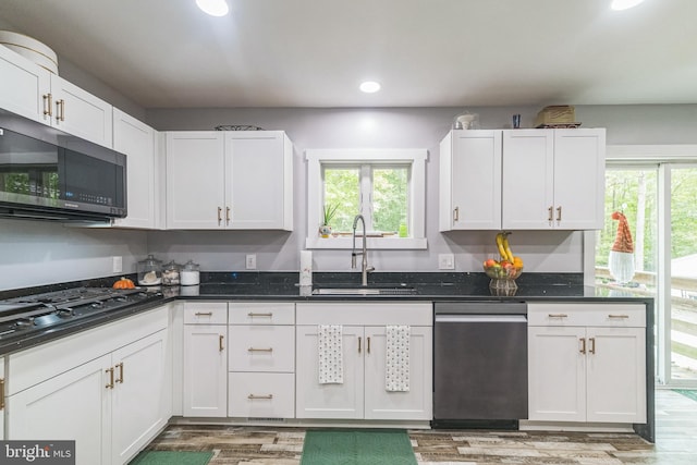 kitchen with black gas cooktop, plenty of natural light, white cabinets, and a sink