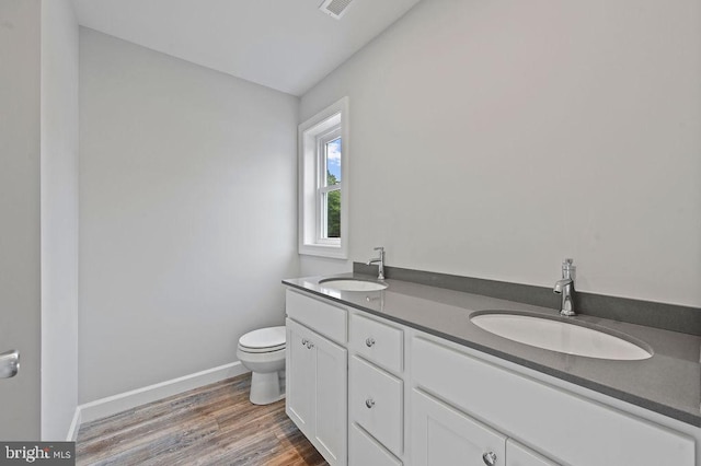 bathroom with hardwood / wood-style flooring, vanity, and toilet