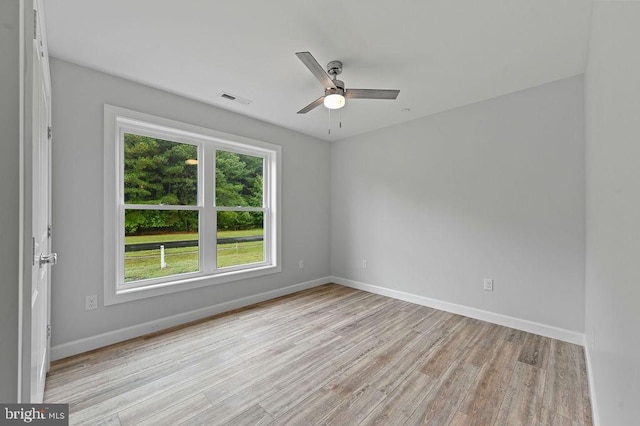 spare room featuring light wood-type flooring, ceiling fan, and a healthy amount of sunlight