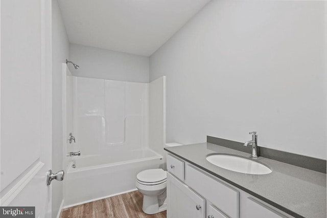 full bathroom featuring wood-type flooring, shower / tub combination, vanity, and toilet