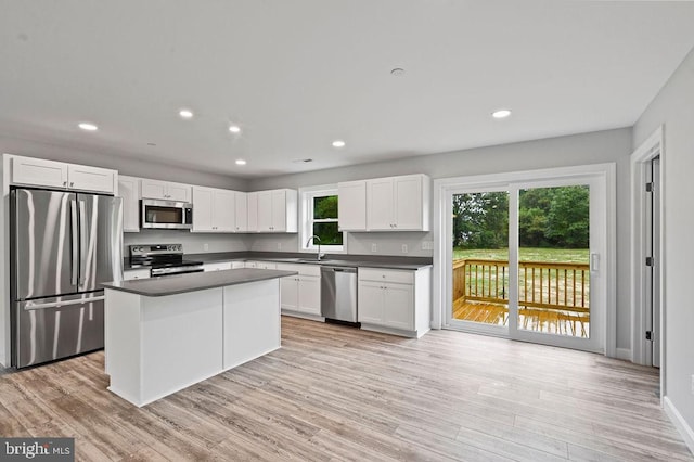 kitchen featuring white cabinets, appliances with stainless steel finishes, light wood-type flooring, and sink