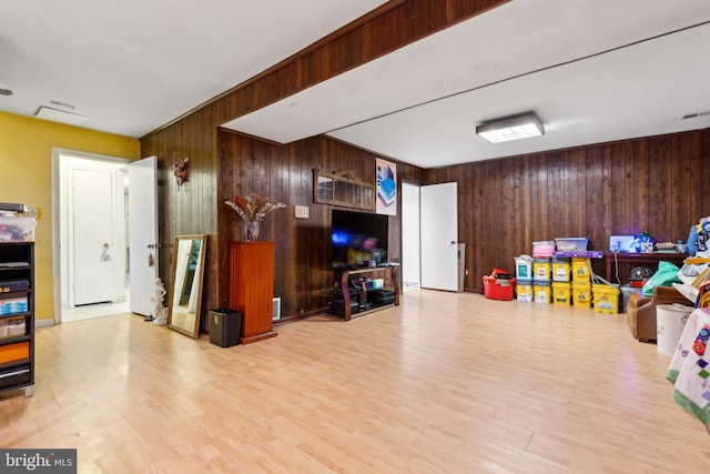 interior space with light wood-type flooring and wood walls