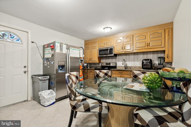 kitchen featuring appliances with stainless steel finishes, plenty of natural light, backsplash, and sink