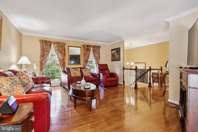 living room with crown molding, hardwood / wood-style flooring, and a chandelier