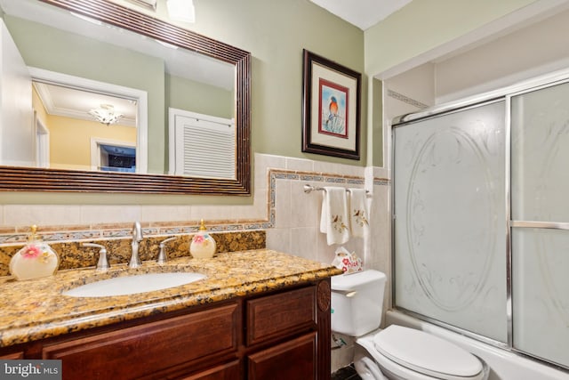 full bathroom featuring vanity, backsplash, tile walls, toilet, and enclosed tub / shower combo