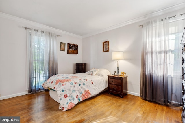 bedroom with crown molding and wood-type flooring