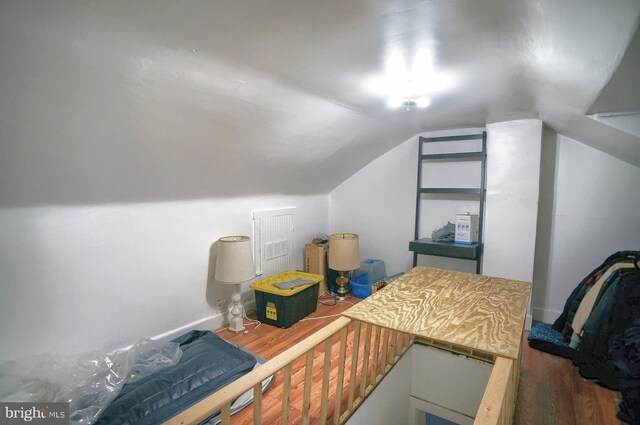 bonus room with hardwood / wood-style floors and vaulted ceiling