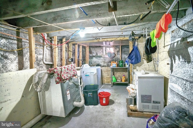 unfinished basement with refrigerator and washing machine and dryer