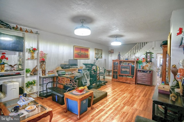 interior space with a textured ceiling and wood finished floors