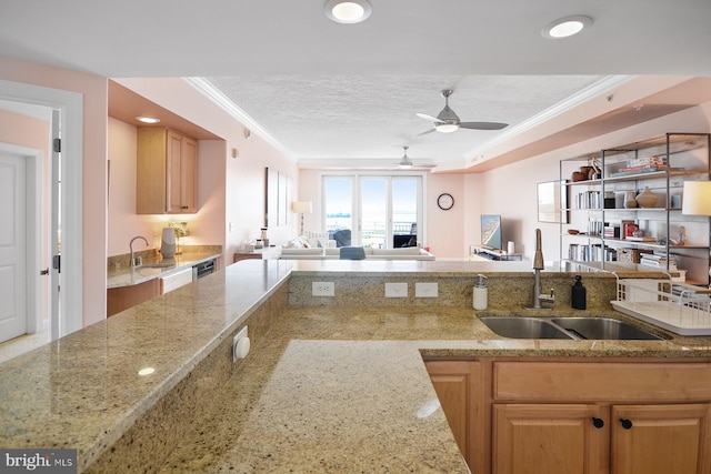 kitchen with a textured ceiling, ornamental molding, sink, ceiling fan, and light stone counters