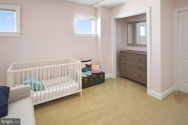 carpeted bedroom featuring a crib