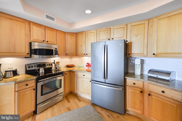 kitchen featuring light hardwood / wood-style flooring, stainless steel appliances, and tasteful backsplash