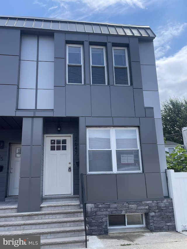 view of front facade featuring a standing seam roof, metal roof, and stucco siding