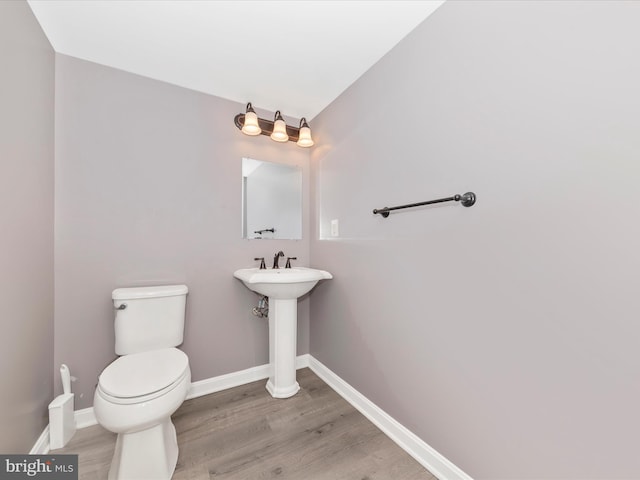 bathroom featuring hardwood / wood-style flooring and toilet