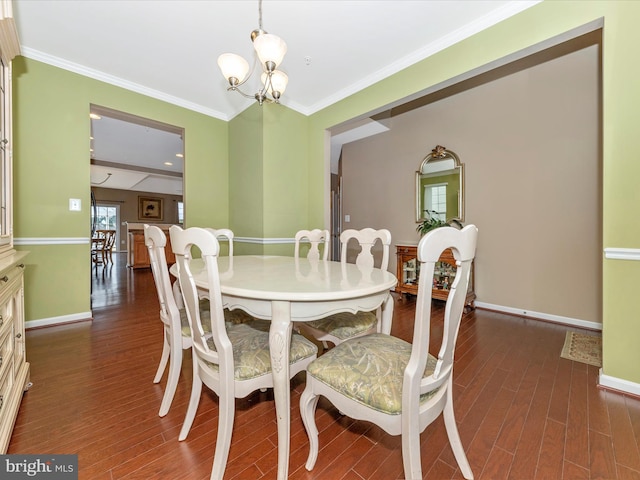 dining room with an inviting chandelier, crown molding, and dark hardwood / wood-style flooring