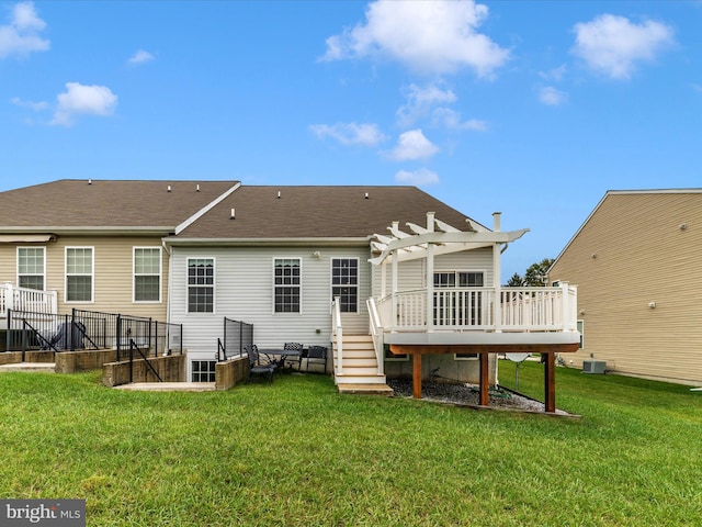 rear view of property featuring a lawn, a pergola, and a wooden deck