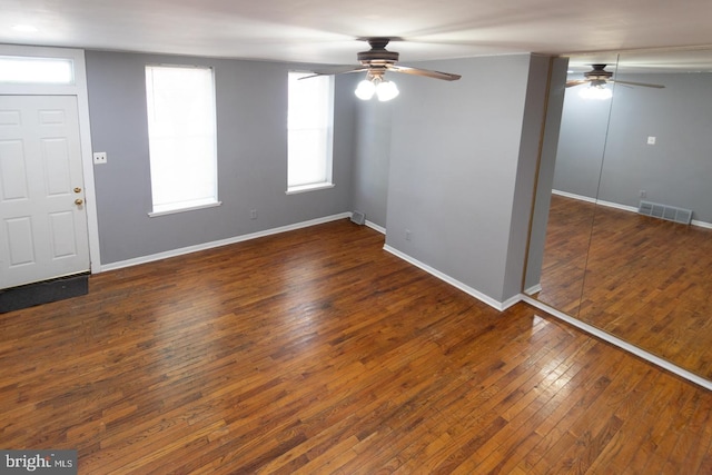 entryway featuring dark wood-style floors, ceiling fan, visible vents, and baseboards