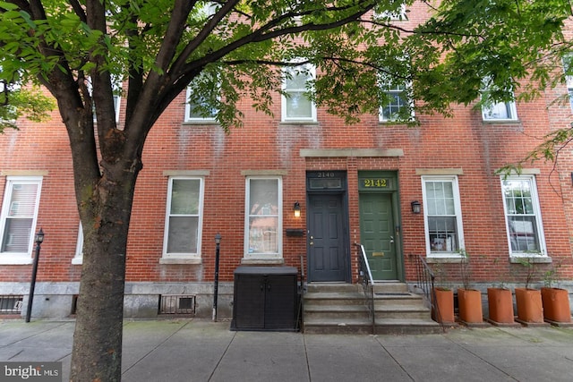 townhome / multi-family property featuring entry steps and brick siding