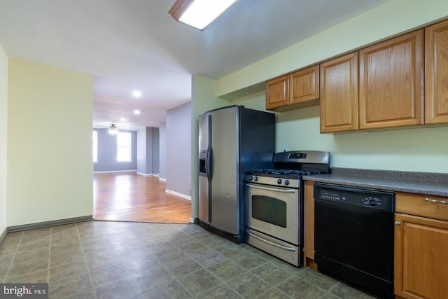 kitchen featuring baseboards, stainless steel appliances, dark countertops, and brown cabinets