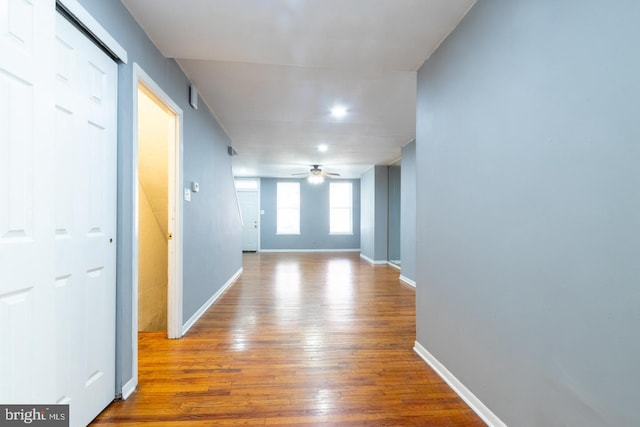 hallway with baseboards and light wood-style floors