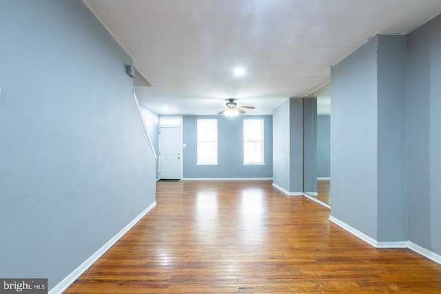 empty room with ceiling fan, baseboards, and wood finished floors