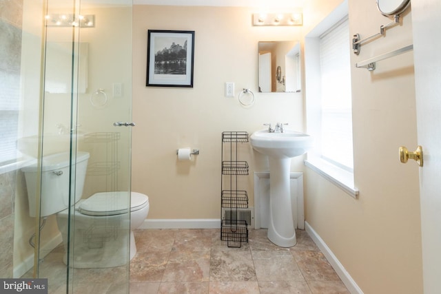 bathroom with a stall shower, baseboards, and toilet