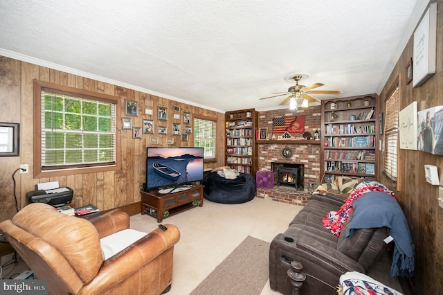 living room with a fireplace, carpet flooring, wooden walls, and plenty of natural light