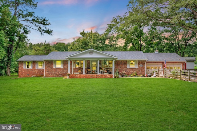 single story home featuring a lawn and a porch