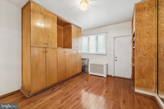 interior space featuring radiator heating unit and hardwood / wood-style flooring