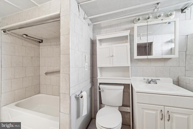 full bathroom with backsplash, toilet, vanity, tile walls, and tiled shower / bath