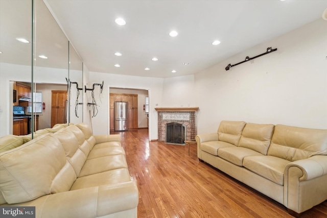 living room featuring hardwood / wood-style flooring and a brick fireplace