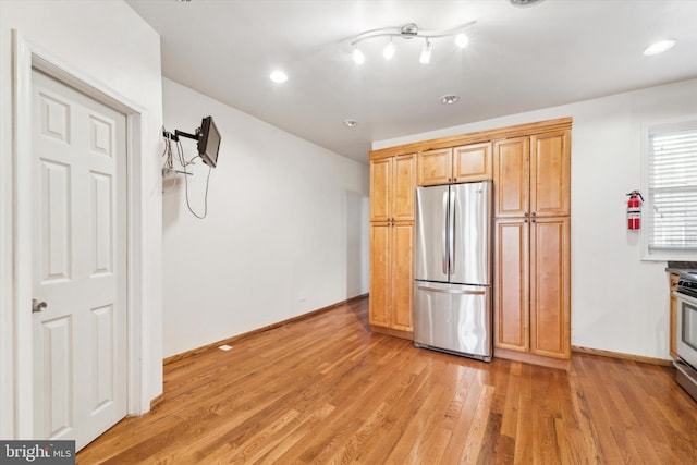 kitchen with stainless steel appliances and light hardwood / wood-style floors