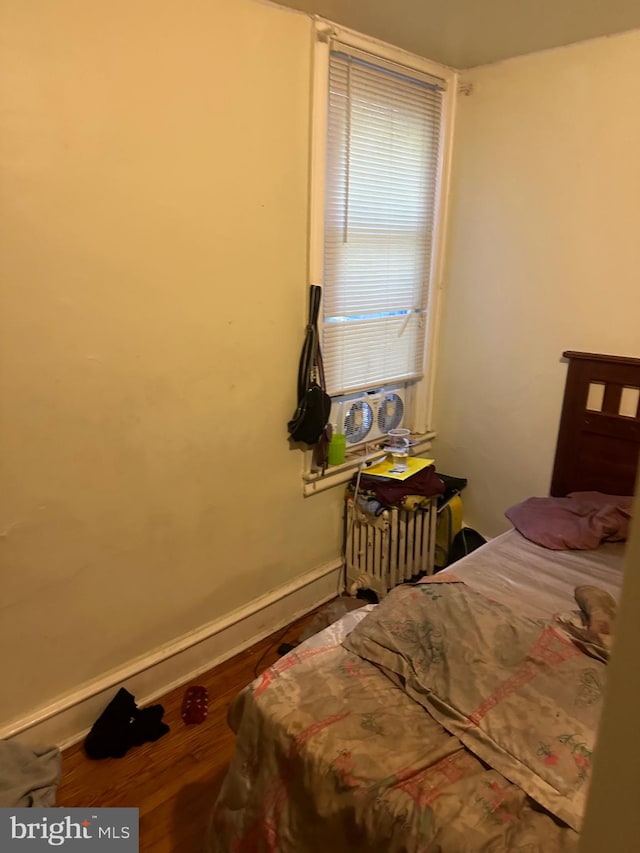 bedroom featuring hardwood / wood-style floors and radiator