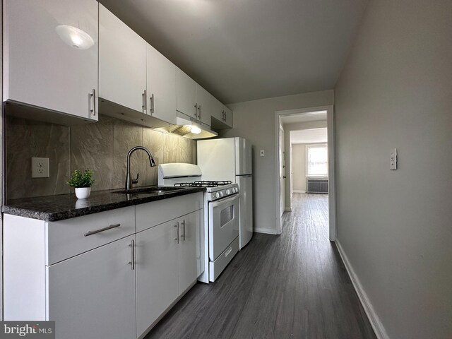 kitchen with decorative backsplash, dark hardwood / wood-style floors, white cabinets, sink, and white appliances