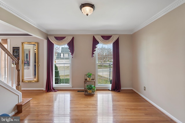 entryway featuring light wood finished floors, stairway, a wealth of natural light, and baseboards