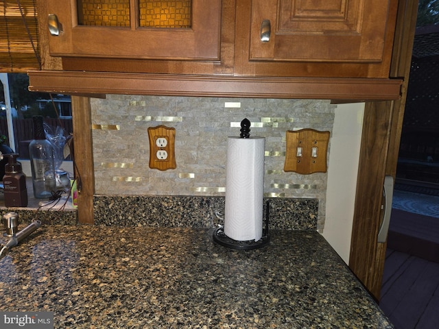 interior details with dark stone counters and brown cabinets