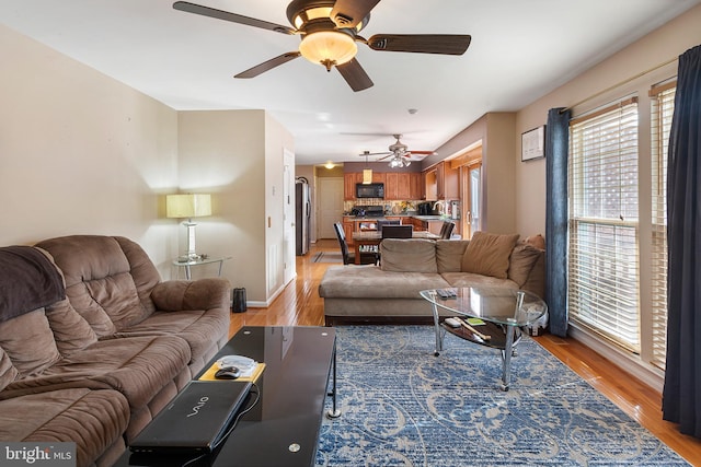 living area with light wood-style flooring and baseboards